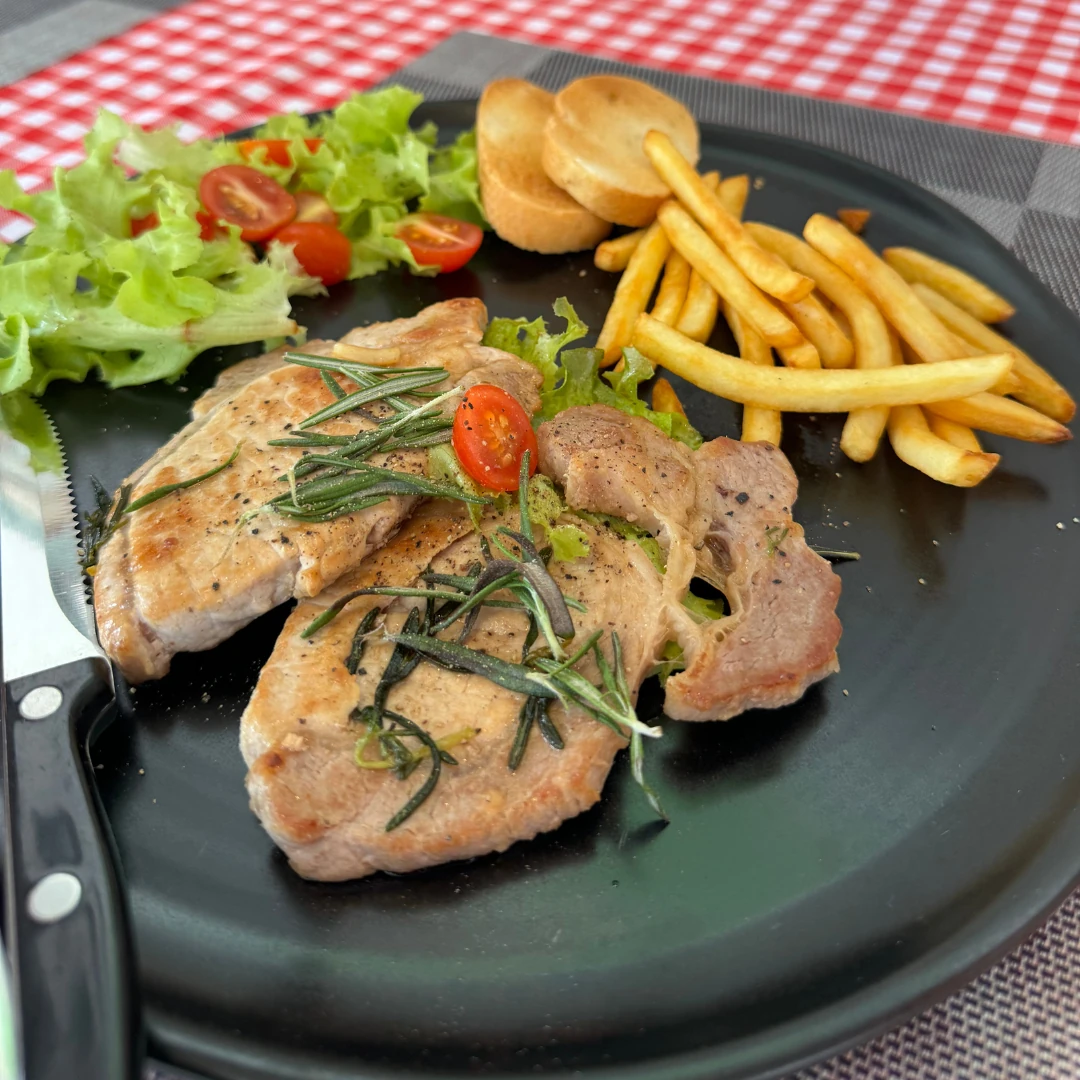 Pork chops with French fries, salad and toasted bread