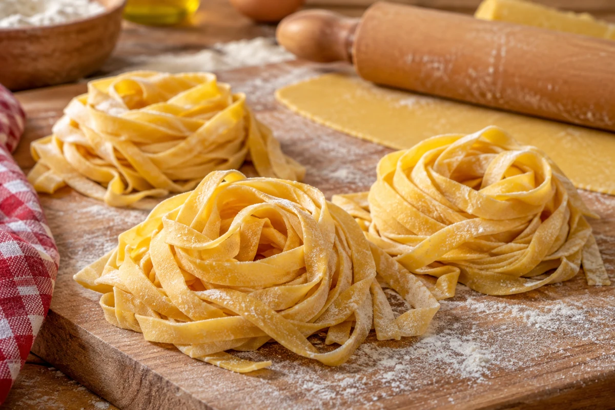 Fresh homemade tagliatelle on a floured pasta board